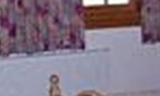 Ein gemütliches Schlafzimmer mit Holzmöbeln und einem großen Fenster. Der Raum ist freundlich und einladend gestaltet.