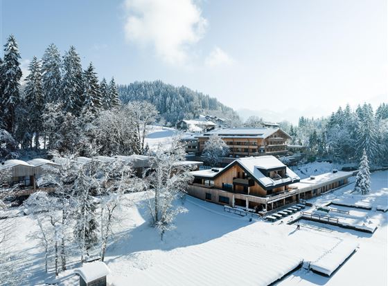 Ein malerisches Winterdorf mit schnee bedeckten Bergen und ruhigen Wäldern. Die Gebäude sind inmitten einer idyllischen Schneelandschaft gelegen.