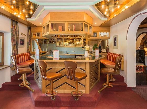 Eine stilvolle Bar mit Holzregalen und gemütlichen Sitzen. Die Beleuchtung sorgt für ein einladendes Ambiente.