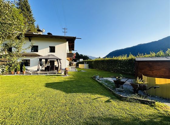 Ein schönes Haus mit einem gepflegten Garten und Blick auf die Berge. Die Umgebung ist grün und einladend, ideal zum Entspannen.