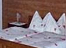 Ein gemütliches Schlafzimmer mit einem Doppelbett und Holzverkleidung. Das Zimmer hat ein Fenster und einen Nachttisch neben dem Bett.