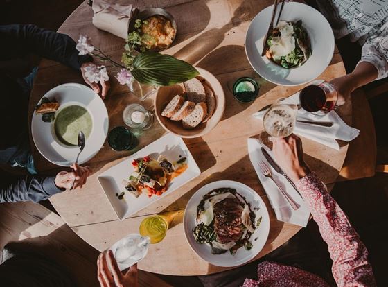 Ein Tisch voller köstlicher Gerichte und Getränke. Die Speisen sind bunt und frisch angerichtet, ideal für ein gemeinsames Essen.