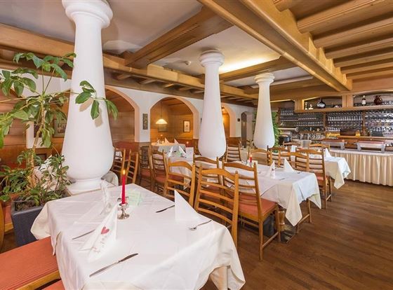 Ein gemütliches Restaurant mit Holzdekor und elegant eingedeckten Tischen. Die Atmosphäre ist warm und einladend.