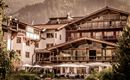Ein charmantes Hotel in den Bergen mit einer einladenden Terrasse. Wunderschöne Natur umgibt die Gebäude.