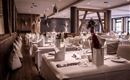 Ein elegantes Restaurant mit geschmackvoll gedeckten Tischen. Die Einrichtung kombiniert Holz und moderne Elemente, ideal für besondere Anlässe.