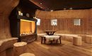 A cozy room with wooden paneling and a fireplace. There are round seating areas and a table in the middle.